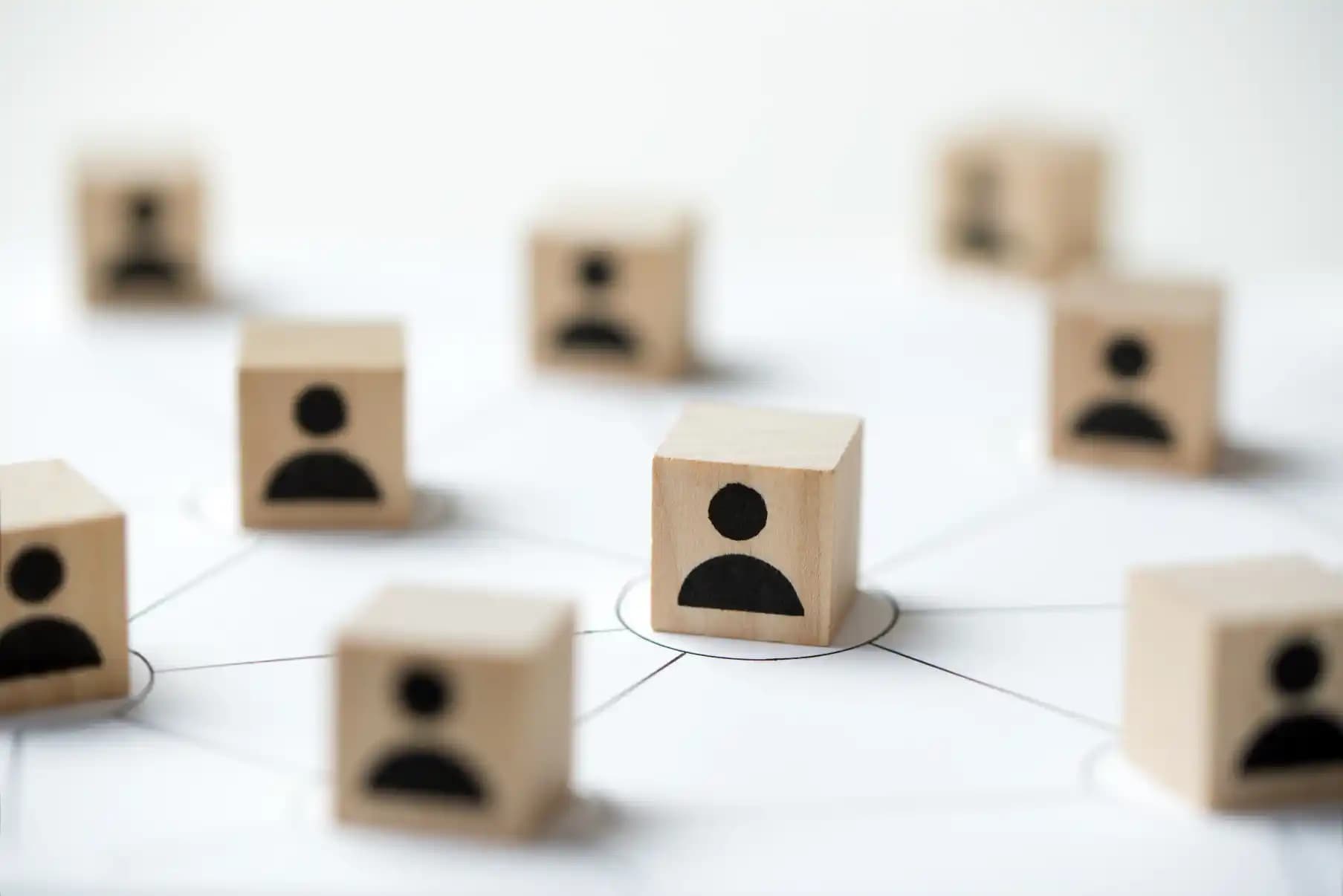 Wooden people blocks connected around one central staffing partner